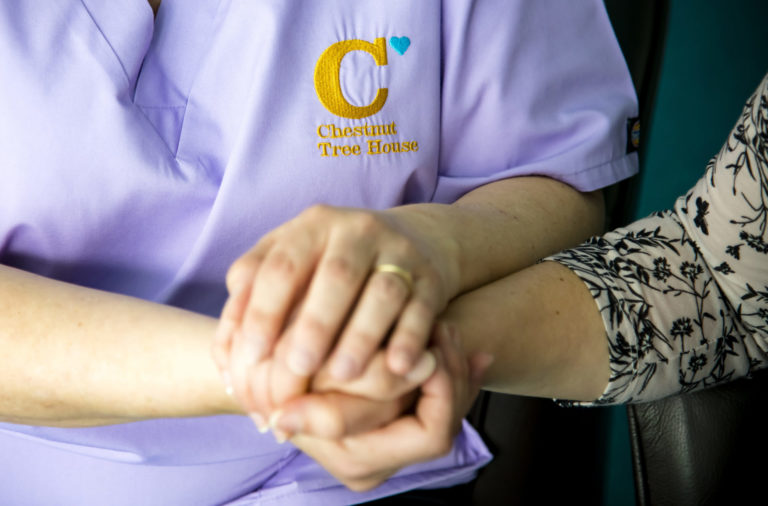 Image of a Nurse holding hands with a parent