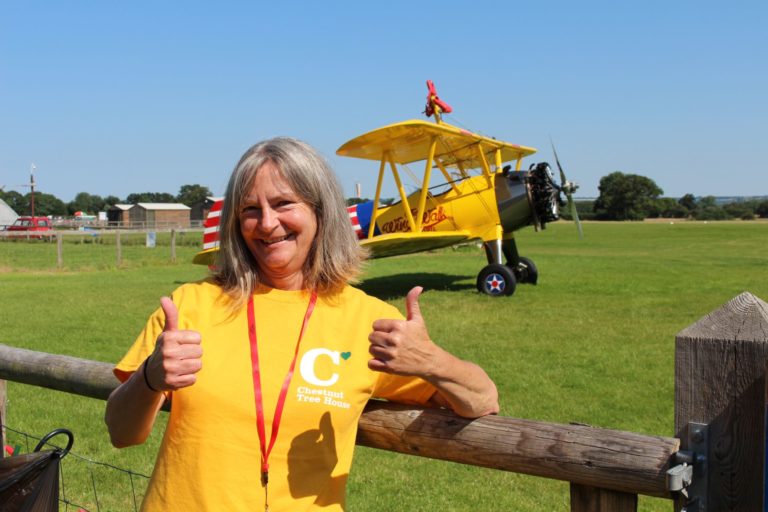 Smiling woman in front of a plane