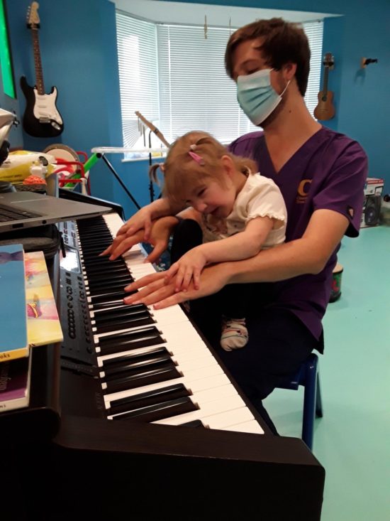 Nurse and child playing piano at Chestnut Tree House