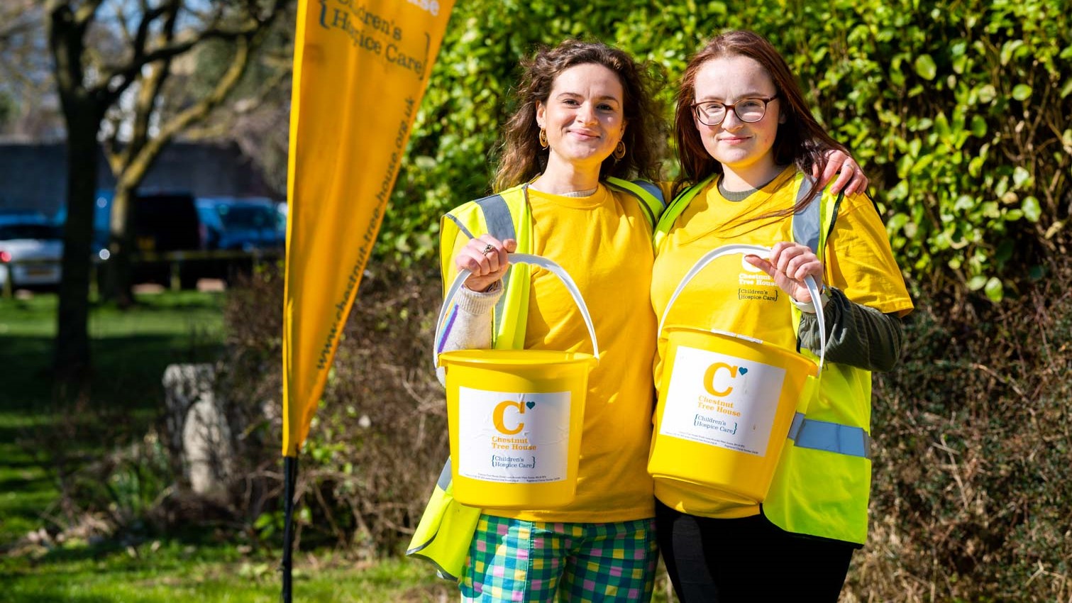 Two volunteers with Chestnut Tree House collection buckets