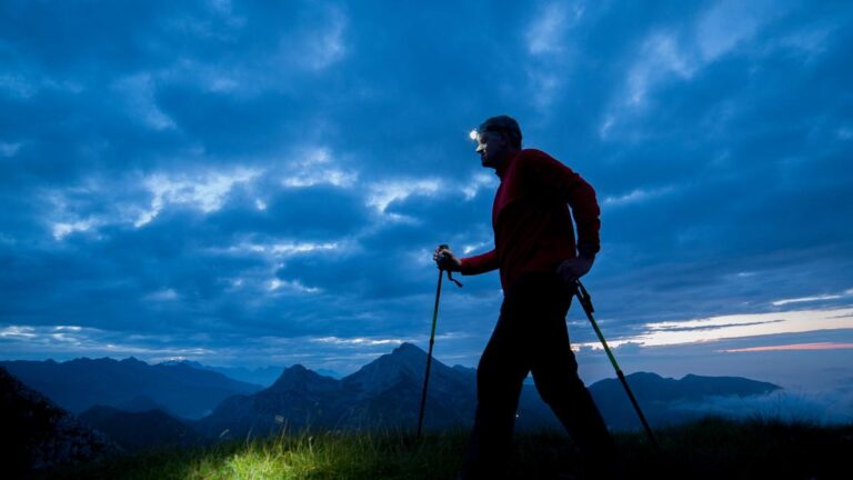 Image of a walker in the dark with mountains behind them