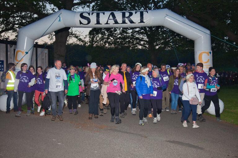 Image of a group of happy participants starting off from the start line of Castle Night Trek 2023