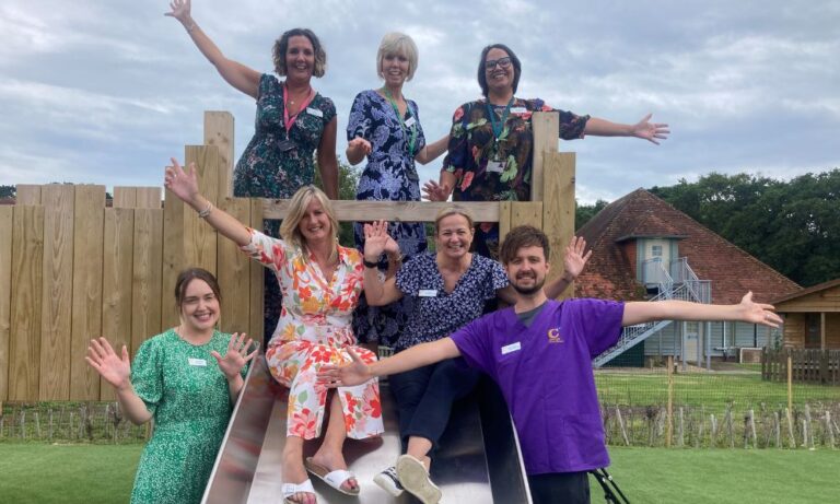 A group of Chestnut Tree House staff - posing on a slide.