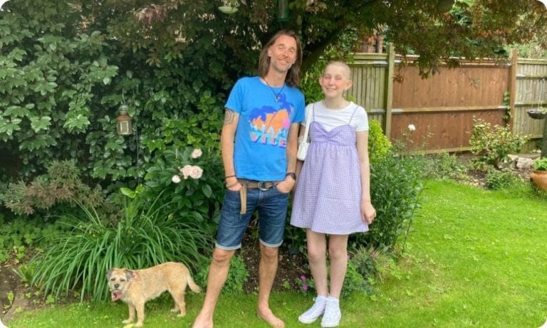 Simon and his teenage daughter Lola stand in a garden smiling