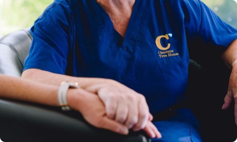 A Chestnut staff member holds someone's hand