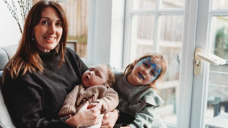 Lynsey cradles baby Raif, with daughter Joni wearing face paint