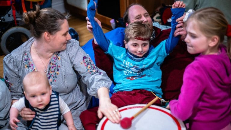 family at chestnut tree house playing with a large drum