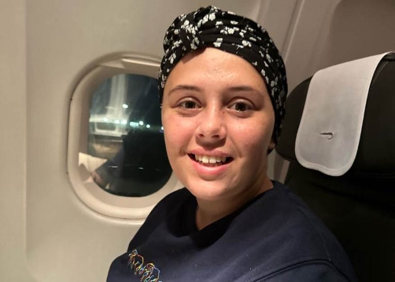 Millie sitting on a aeroplane, smiling at the camera