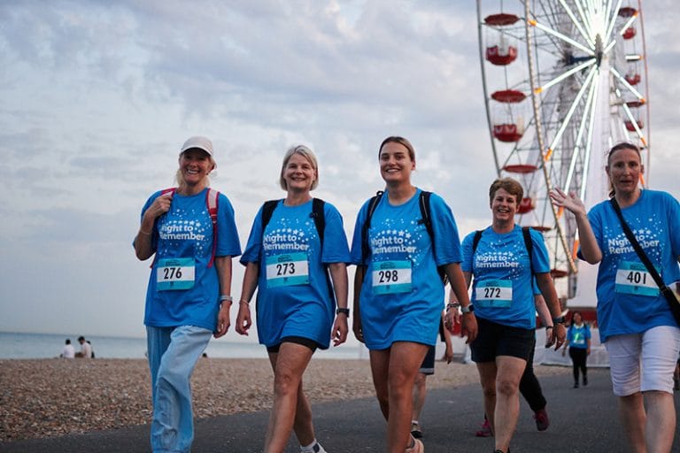A group of walkers taking part in night to remember wakling along worthing seafront prom
